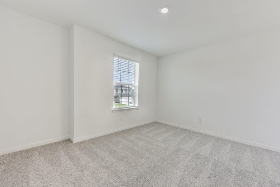 Bright interior space featuring a window with blinds, recessed lighting, neutral paint, and light-toned carpet flooring