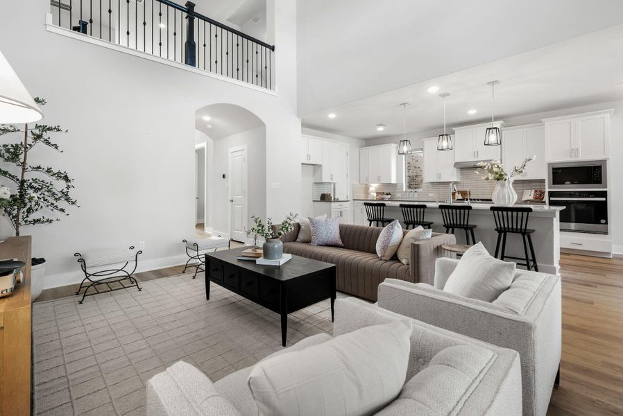 An inviting open-concept living space features high ceilings and seamless flow to a modern kitchen.