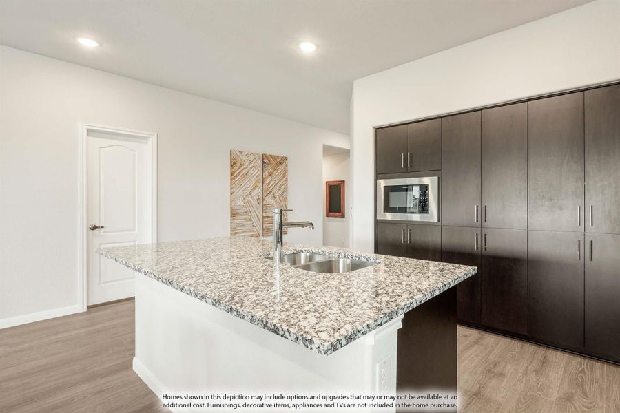 Kitchen island with granite countertop and sink, dark wood cabinets, and built-in microwave on wood floors Kitchen island with granite countertop and sink, dark wood cabinets, and built-in microwave on wood floors