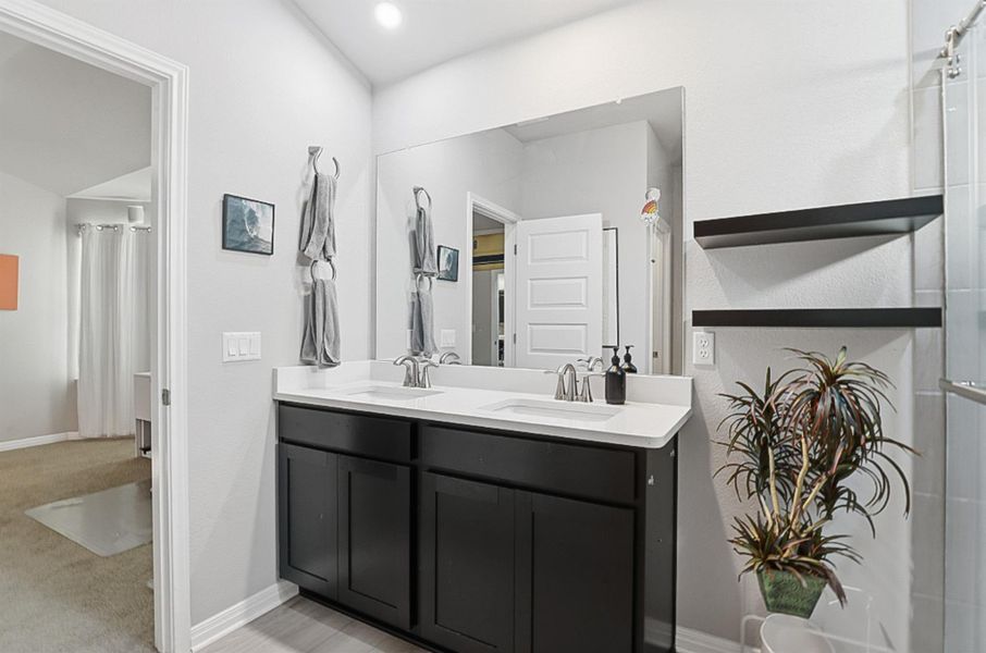 The primary ensuite features a dual vanity and floating shelves.