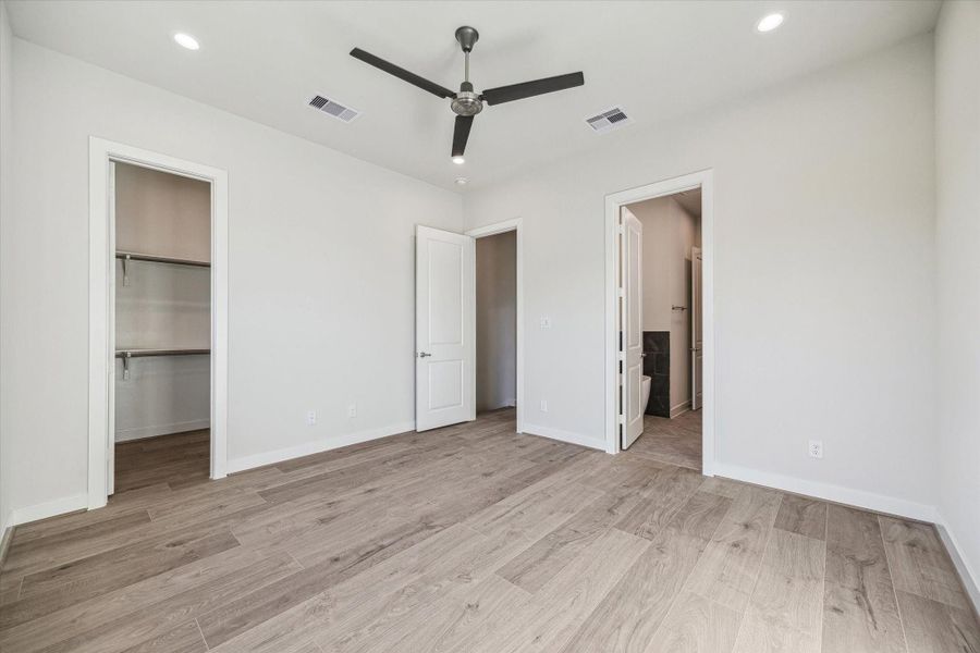 Experience true tranquility in this spacious bedroom, featuring a minimalist aesthetic, a large walk-in closet, and private access to the ensuite bath.