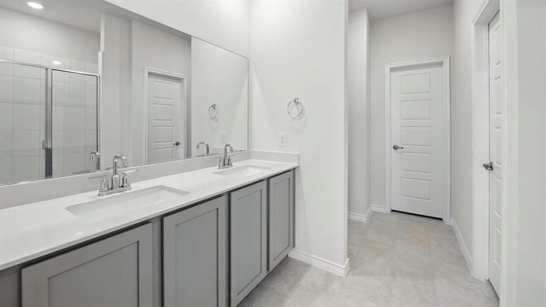 Bathroom featuring double vanity, a shower stall, recessed lighting, and light tile patterned floors