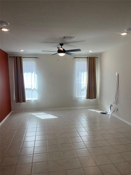 Spare room with light tile patterned floors, ceiling fan, recessed lighting, and a textured ceiling Spare room with light tile patterned floors, ceiling fan, recessed lighting, and a textured ceiling