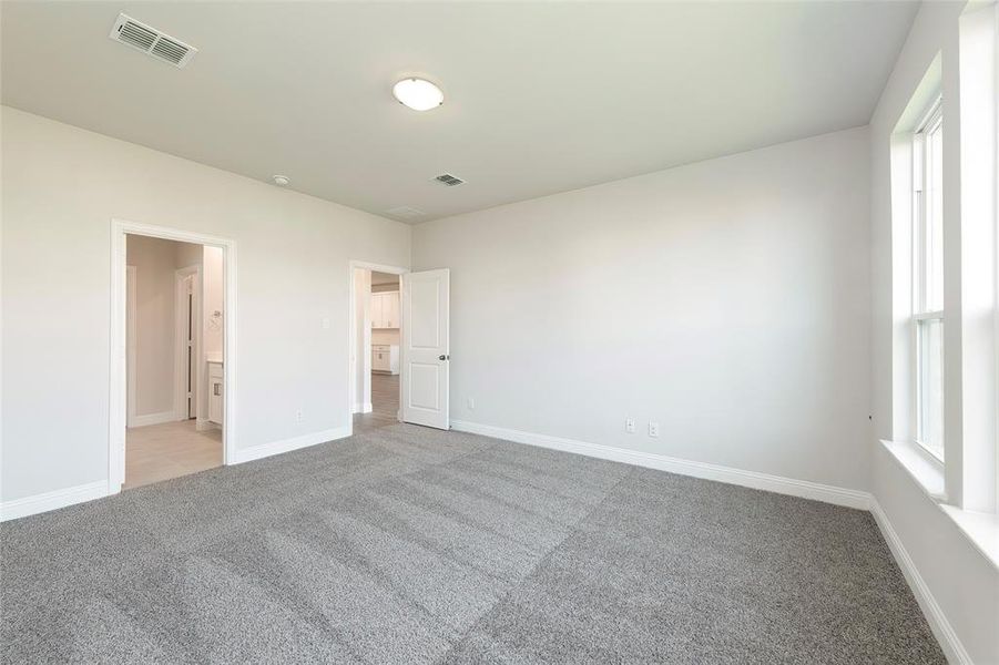 Unfurnished bedroom with light colored carpet and baseboards Unfurnished bedroom with light colored carpet and baseboards