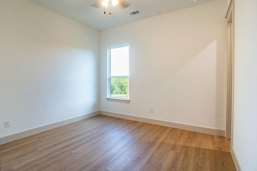 Empty room featuring ceiling fan and light wood finished floors Empty room featuring ceiling fan and light wood finished floors
