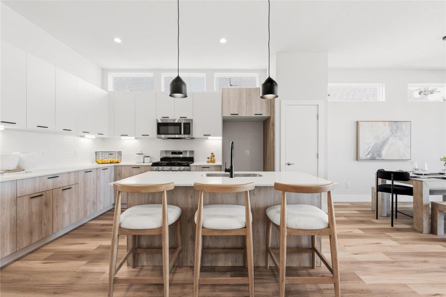 A generous island sits at the center of the kitchen, complemented by under-cabinet lighting and a full walk-in pantry, storage and prep space designed to actually keep the counters clear.