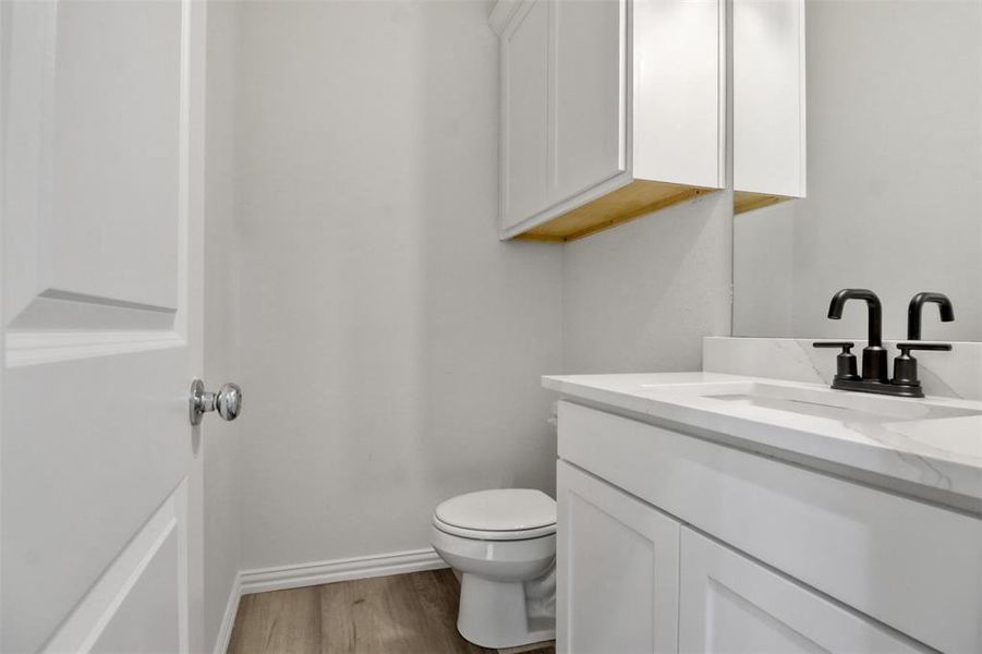 Bathroom featuring hardwood / wood-style flooring, toilet, and large vanity