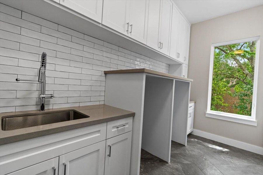 Laundry room on second floor has full size sink and more storage, drip dry not pictured