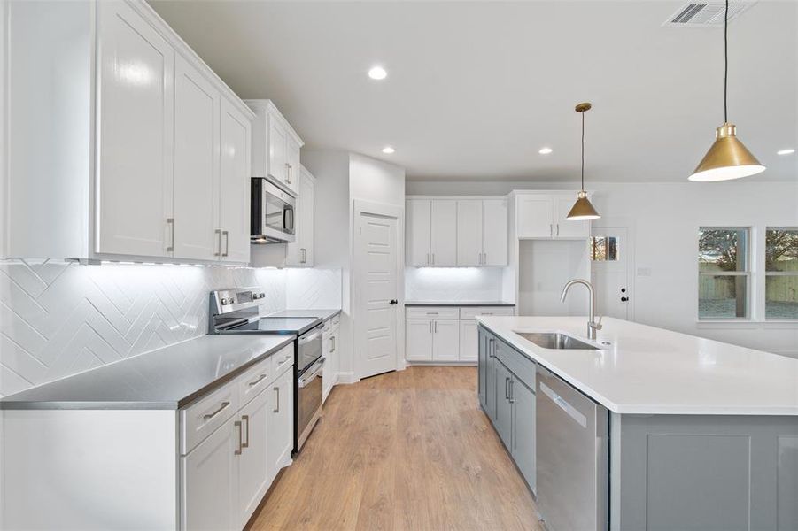 Kitchen featuring white cabinets, sink, and appliances with stainless steel finishes