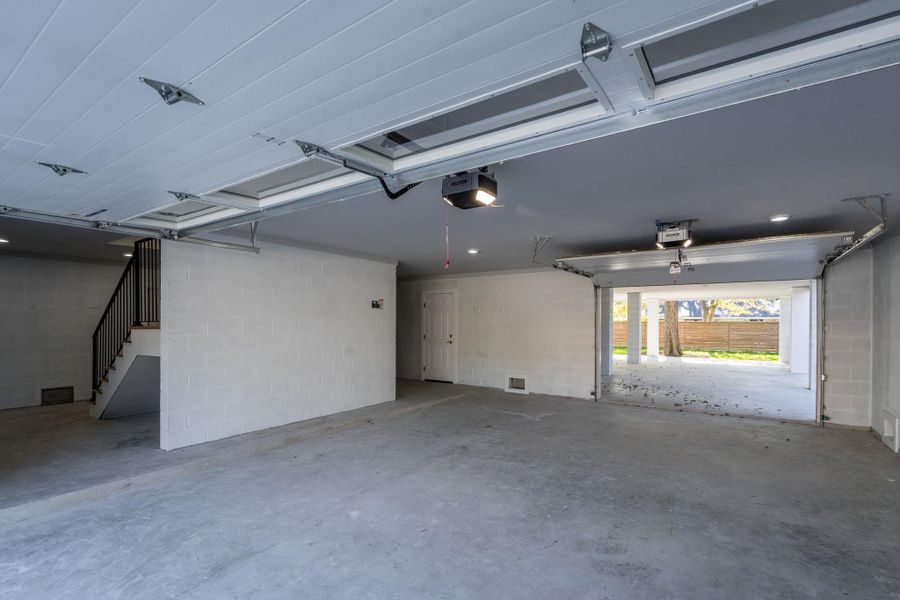 Large garage with extra space for storage leading to the carport in the back.