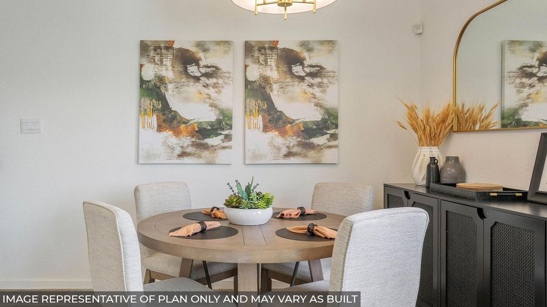 Dining area featuring a circular wood-finish table, upholstered dining chairs, and a contemporary overhead light fixture