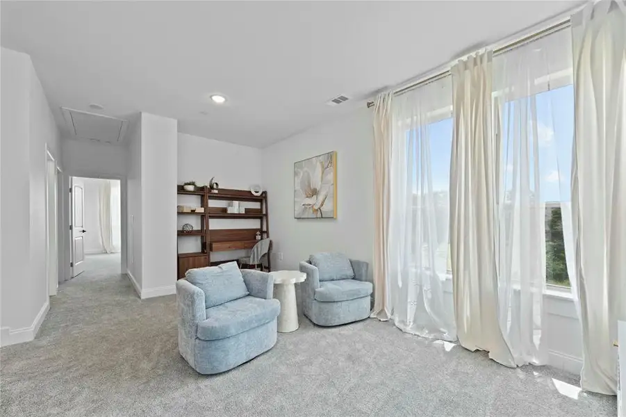 Living area with attic access, carpet floors, baseboards, and recessed lighting