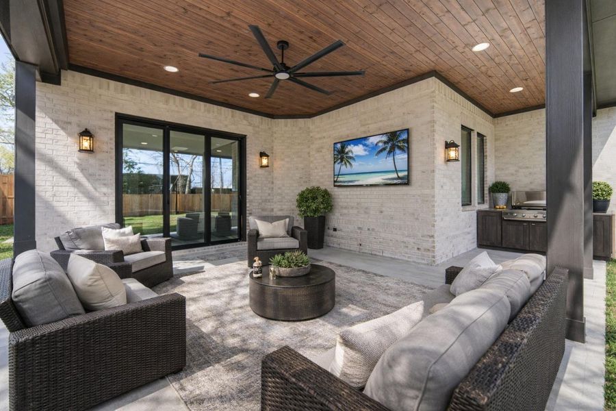 Stunning outside covered area that is preplumbed for an outdoor kitchen. *This home is virutally staged and the outdoor kitchen show is for ideas Stunning outside covered area that is preplumbed for an outdoor kitchen. *This home is virutally staged and the outdoor kitchen show is for ideas