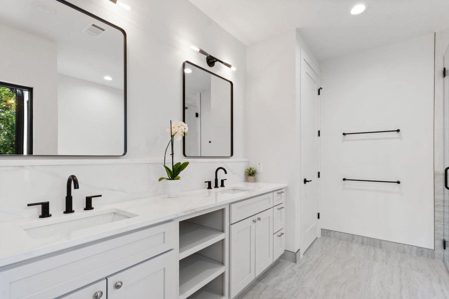 Dual vanity with sleek black fixtures and a spacious countertop provides ample room for personal care. Dual vanity with sleek black fixtures and a spacious countertop provides ample room for personal care.
