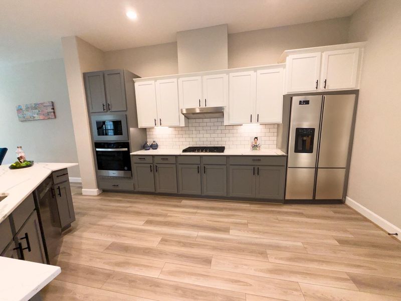 The ROCburne’s kitchen combines style and efficiency with spacious countertops, designer cabinetry, and an open-concept layout that keeps you connected to the heart of the home. Image depicts home as-is with some virtually elements.