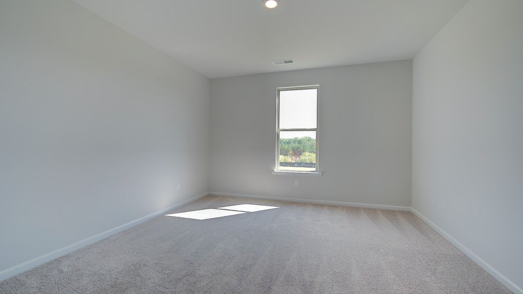 McKinley II secondary bedroom with carpet flooring and natural light at Brighton in Locust Grove, GA.