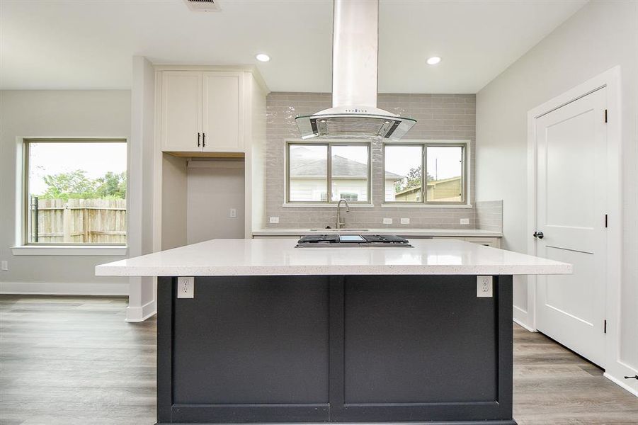 Modern kitchen featuring sleek countertops, stainless steel appliances, ample natural light, and an open floor plan, perfect for entertaining.