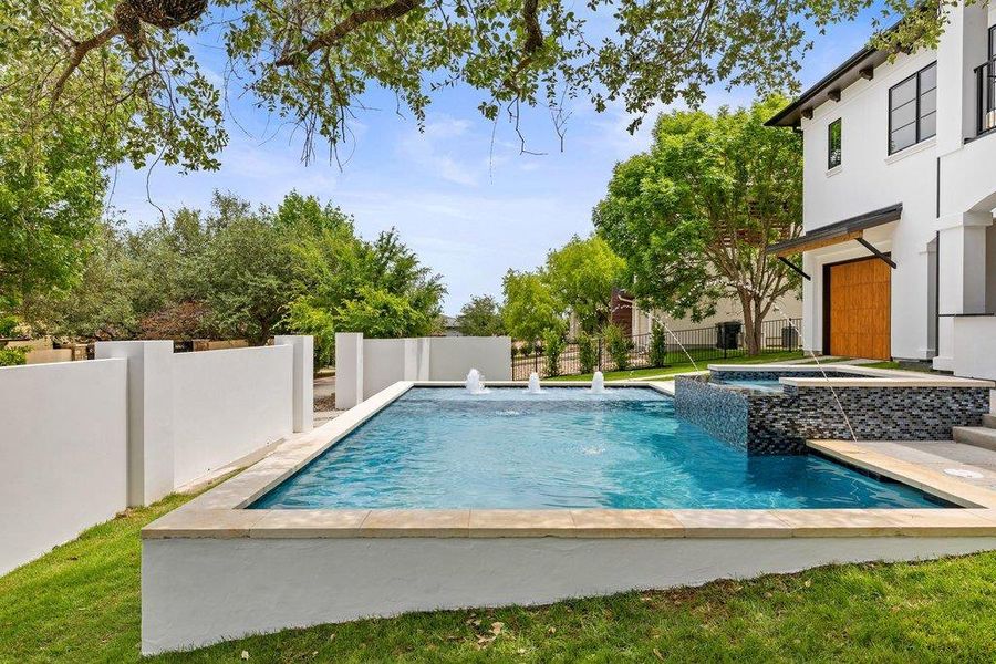 Outdoor swimming pool featuring water features and an integrated spa