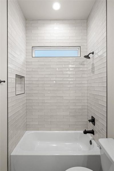 Full bath featuring  shower combination and healthy amount of natural light