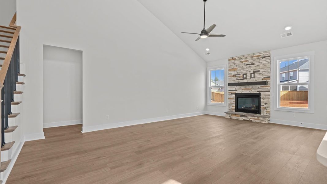 Spacious and stylish family room with two-story ceilings that create a bright and open atmosphere