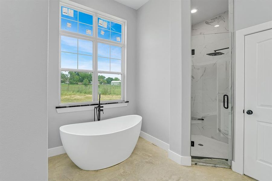 Bathroom with baseboards, a marble finish shower, and healthy amount of natural light