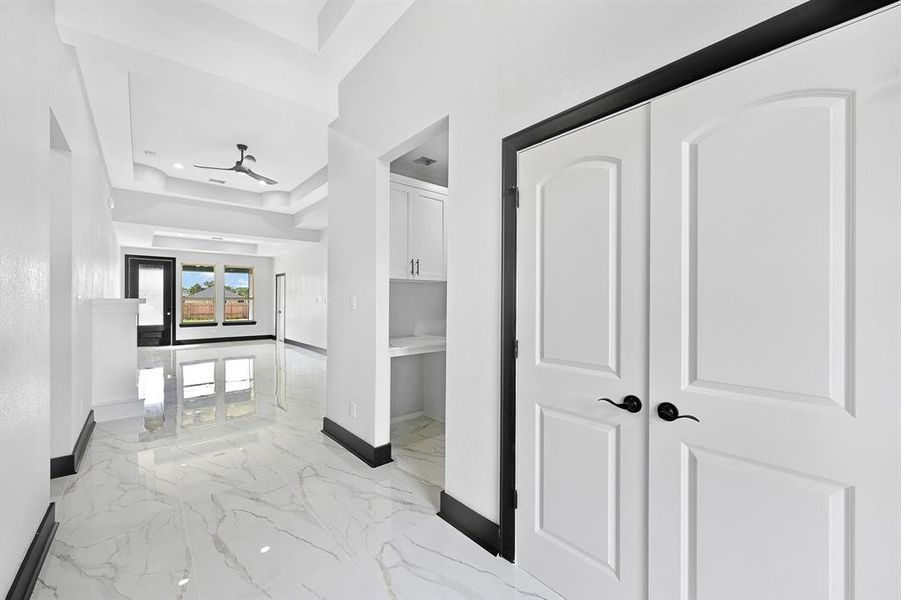 Step into the grand entrance featuring sleek modern tall door and a spacious double-door coat closet.