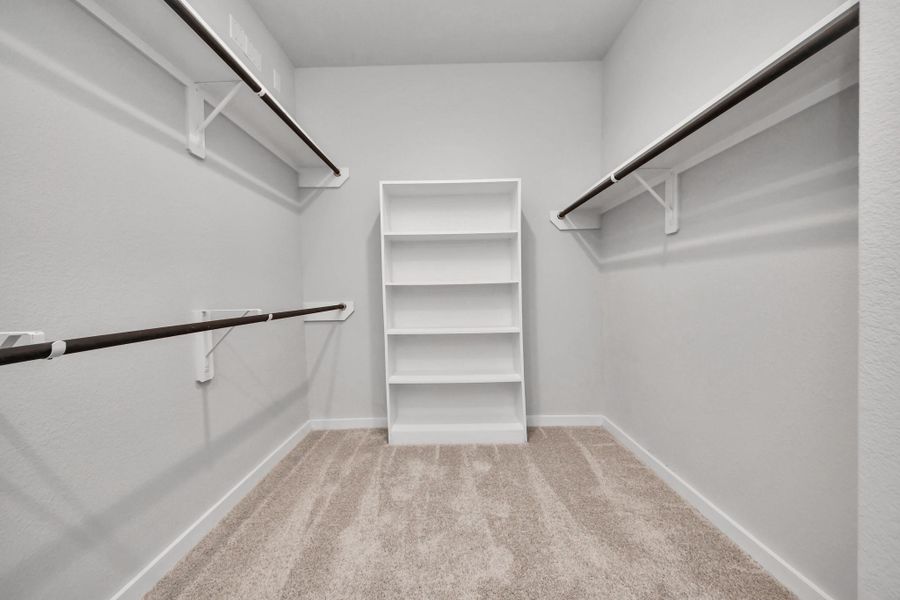 Walk-in closet that epitomizes luxury and practicality. This generously sized space features built-in shelving, offering abundant room for impeccable organization. High ceilings and recessed lighting create a bright and welcoming ambiance.
