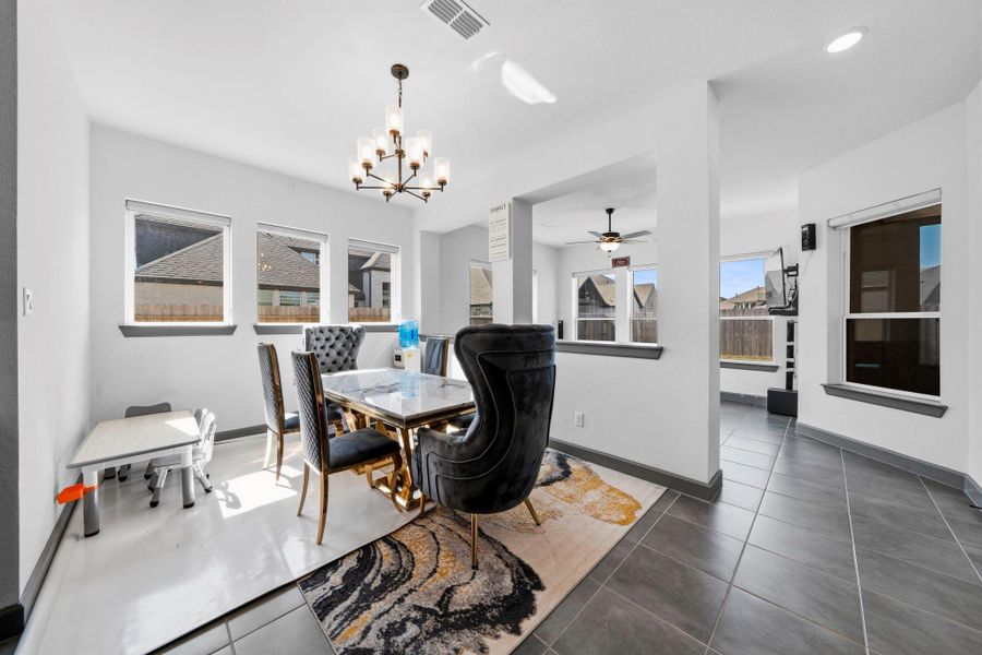 Bright dining space with elegant chandelier, large windows, and an open layout ideal for gatherings.