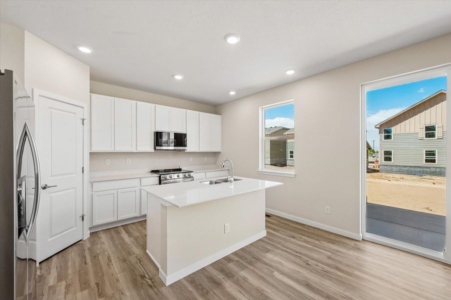 A kitchen with white cabinets.
