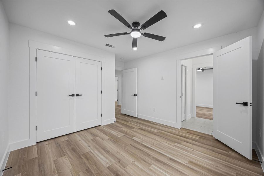 Room featuring wood-finish flooring, recessed lighting, and a contemporary ceiling fan Room featuring wood-finish flooring, recessed lighting, and a contemporary ceiling fan