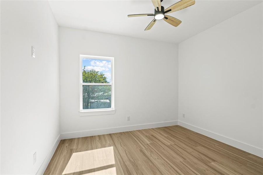 Empty room with light wood-style flooring and ceiling fan