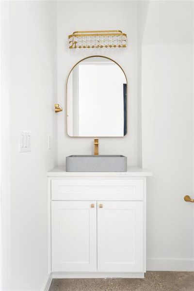 Half bath downstairs for guests to use, spacious with gold accents