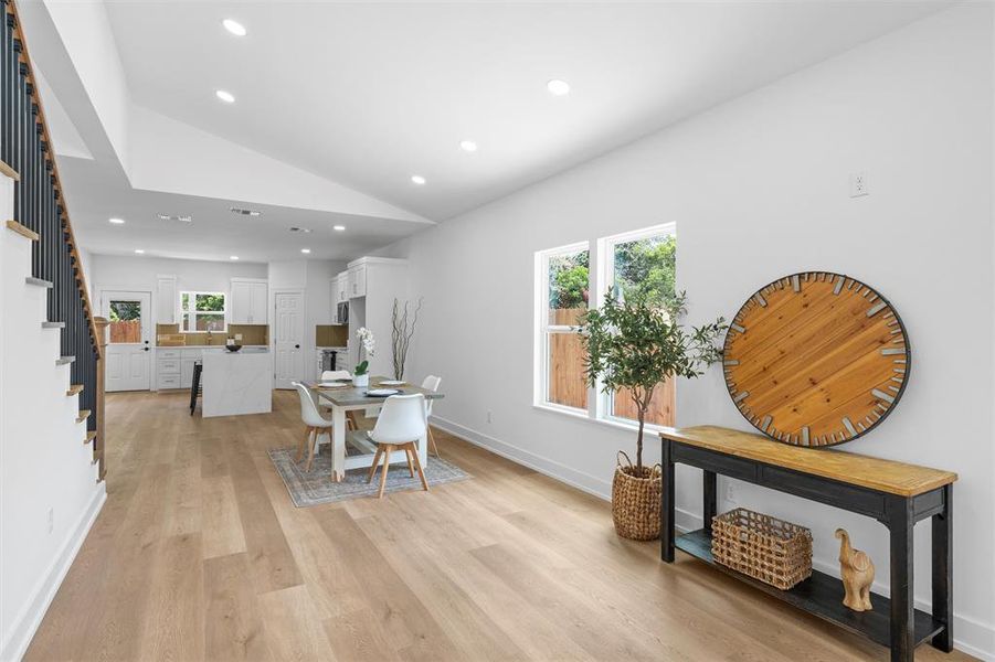 Dining room with stairway, recessed lighting, vaulted ceiling, and light wood-style flooring Dining room with stairway, recessed lighting, vaulted ceiling, and light wood-style flooring