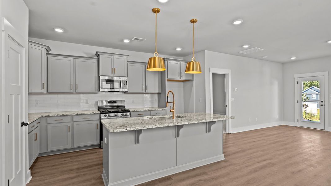 Highly skilled kitchen design includes a 7-foot island, quartz countertops, and stylish pendant fixtures