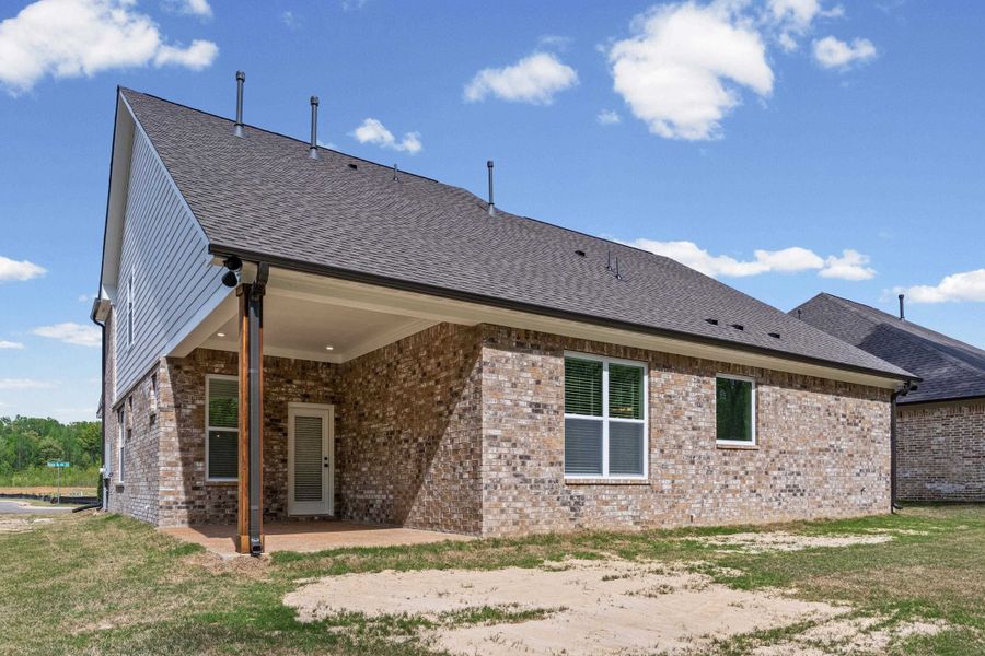 Rear view of house featuring brick siding, a patio area, and roof with shingles Rear view of house featuring brick siding, a patio area, and roof with shingles