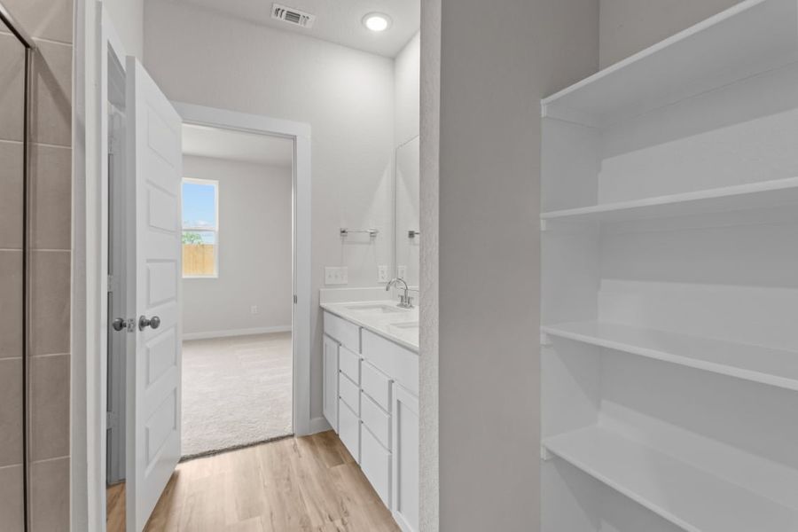 A bathroom with white cabinets.
