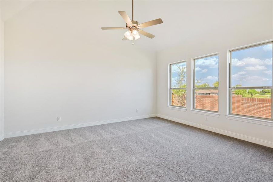 Spare room featuring ceiling fan, carpet flooring, and high vaulted ceiling