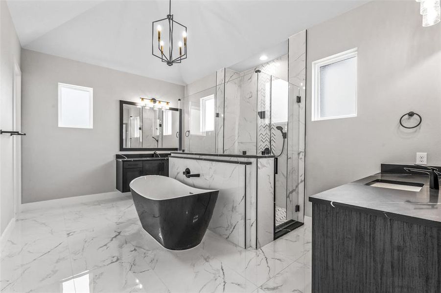 Bathroom with double vanity, shower with separate bathtub, tile patterned flooring, and a chandelier