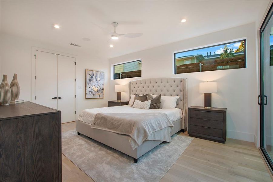 Bedroom with ceiling fan, a closet, and light wood-type flooring