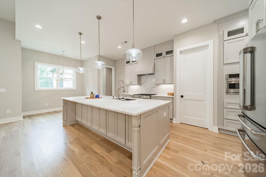 Fabulous Chef's Kitchen with oversized Gas Range and Oven, Quartz Counter Tops and Backsplash, and Custom Cabinetry