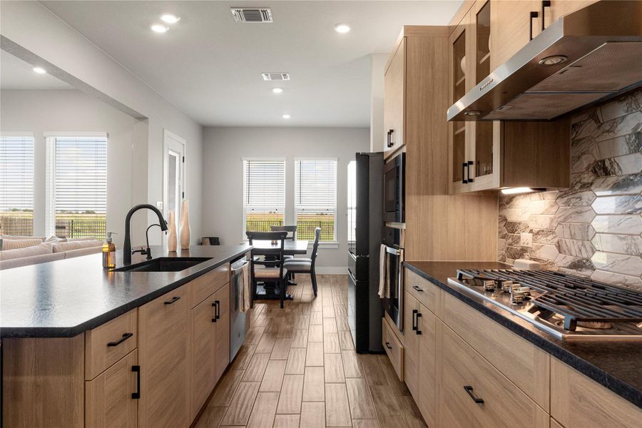Culinary excellence awaits in this modern kitchen featuring a gas range and sleek dark countertops. Culinary excellence awaits in this modern kitchen featuring a gas range and sleek dark countertops.