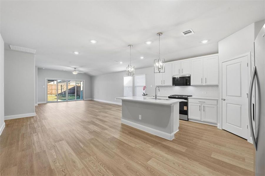 Kitchen with plenty of natural light, pendant lighting, open floor plan, white cabinetry, and recessed lighting