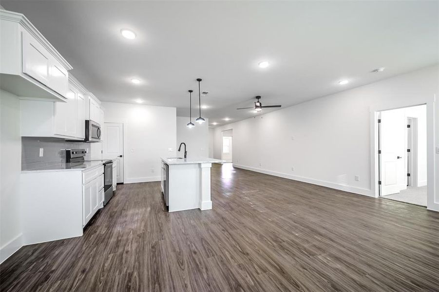 Kitchen featuring light countertops, a sink, a ceiling fan, stainless steel appliances, and dark wood-type flooring Kitchen featuring light countertops, a sink, a ceiling fan, stainless steel appliances, and dark wood-type flooring