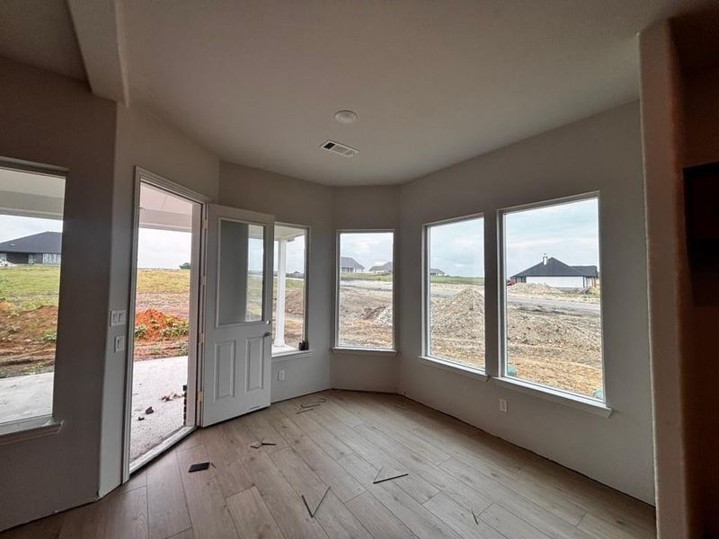 Interior space featuring a bank of four large windows, wood-finish flooring, and a glass-paneled door