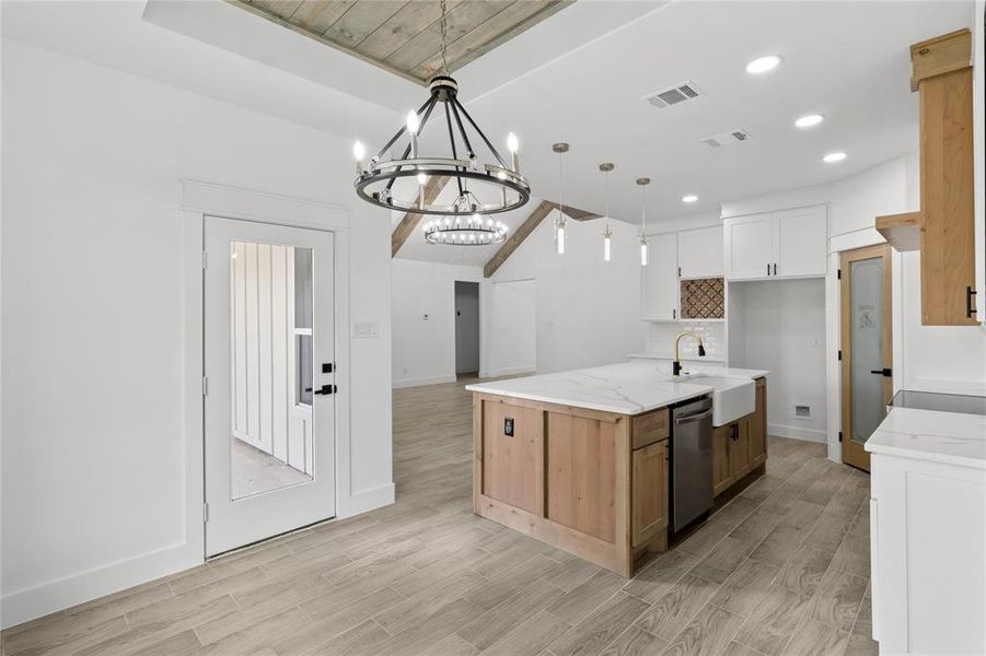 Kitchen with hanging light fixtures, sink, light hardwood / wood-style flooring, and white cabinetry