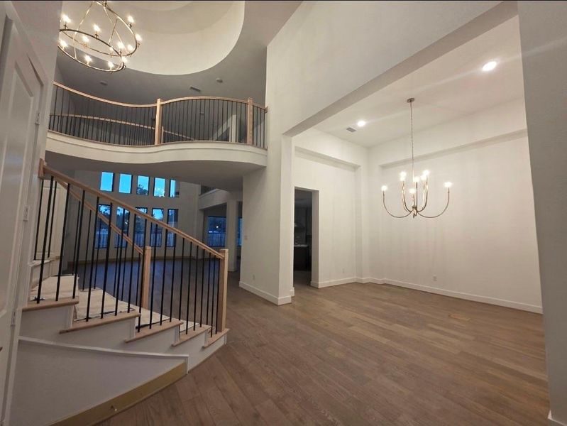An entry designed to impress, double hight ceiling, curved staircase, and statement lighting even in the formal dinning.