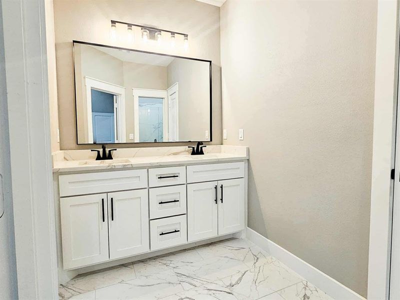 Master bath w/ dual sinks, quartz shower, custom flooring and cabinets.