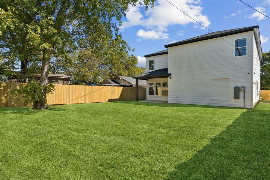 Rear view of property with a fenced backyard and a patio area