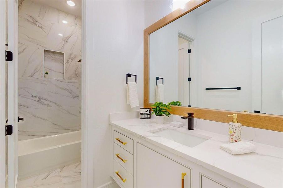 Bathroom featuring tile patterned flooring, vanity, and tiled shower / bath combo