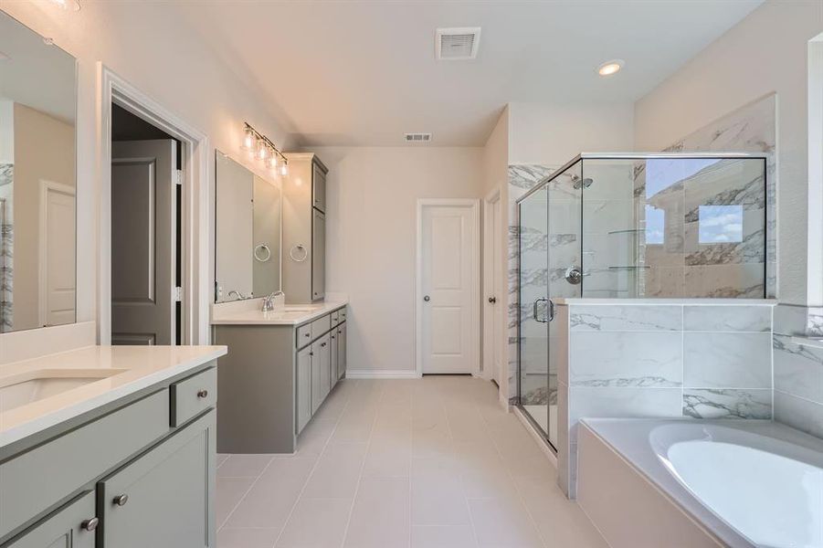 Primary bathroom with vanity, tile patterned floors, and separate shower and tub